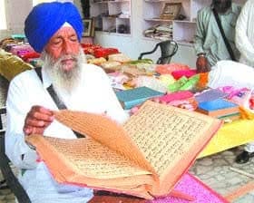 Jathedar Dalip Singh Ji reading a pothi. Photograph supplied for this archive.